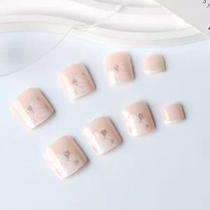 Dettaglio di unghie dei piedi rosa nude con fiori di camelia bianchi e glitter argento