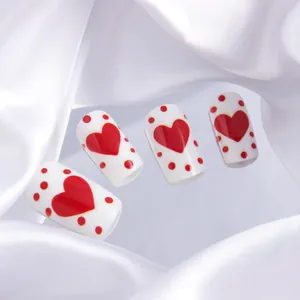 Detailed view of square fake nails with red hearts and polka dots for Valentine's Day