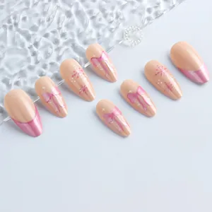 Detail of almond-shaped pink bow press-on nails with French gradient and star motifs