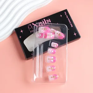 Dettaglio di unghie finte sfumate rosa con frecce di Cupido dorate e design a cuore