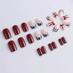 Medium square press-on nails with red bows, snowflakes and French tip design
