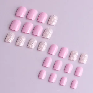 Short square pink glossy press-on nails with white flowers and small crystal accents