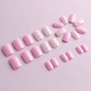 Short square glossy pink press-on nails set with white flower patterns and rhinestones