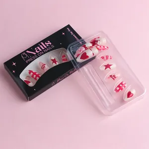 Detail view of almond press-on nails with red heart and cherry patterns in a black box