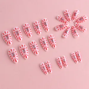 Pink almond press-on nails with red heart patterns and silver glitter accents