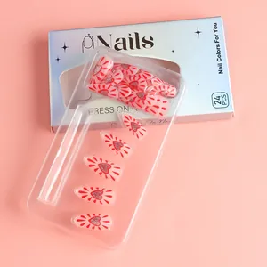 Close-up of 24pcs pink press-on nails with red glitter hearts in elegant blue packaging