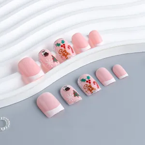 Pink Christmas press-on nails with cartoon gingerbread man and glitter tree designs