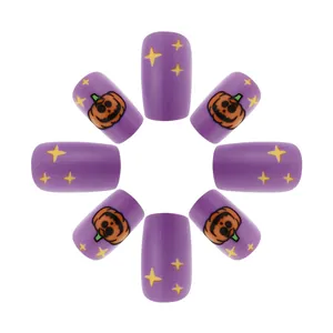 Close-up of matte purple press-on nails with Halloween pumpkin and star patterns