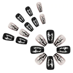 Glossy black press-on nails with silver glitter hearts and flame designs on coffin shape