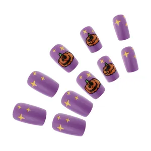 Detail of matte purple Halloween press-on nails with cute pumpkin and star patterns