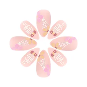 Detail of pink matte almond press-on nails with retro floral and golden petal patterns