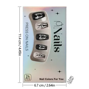 Detail of press-on nails set with black glitter heart and flame patterns in holographic box