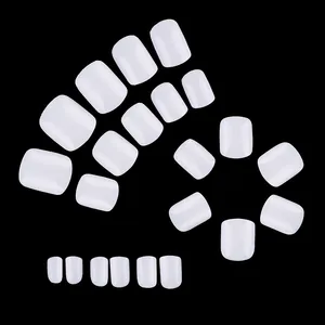Macro detail of white square artificial nails arranged by size on a black background