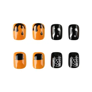 Détail de faux ongles d'Halloween avec motifs de citrouilles, fantômes et toiles d'araignées