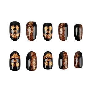Short glossy Halloween press-on nails with glitter pumpkin face design in black and gold