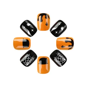 Détail de faux ongles courts Halloween avec motifs citrouille pailletée et toile d'araignée