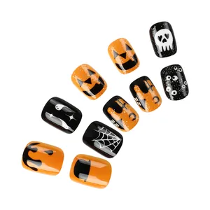 Détails de faux ongles d'Halloween avec paillettes, motifs citrouille et toile d'araignée