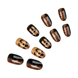 Detail of short pumpkin face press-on nails with black and orange glitter gradient