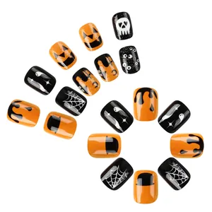 Faux ongles Halloween avec motifs citrouille à paillettes et toile d'araignée