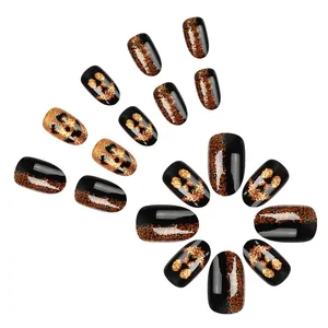 Short glossy pumpkin face press-on nails with orange glitter for Halloween