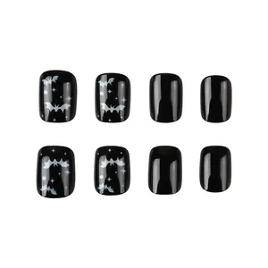 Glossy black Halloween press-on nails featuring white bat and star patterns detail