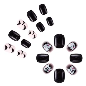 Detail of Halloween press-on nails with bat silhouettes, ghost faces, and glitter finish