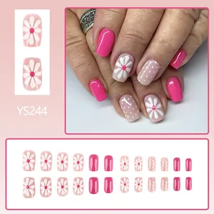 Short square press-on nails with white daisy patterns and pink polka dot glossy finish