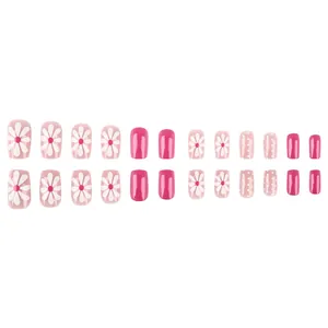 Short pink press-on nails with white daisy floral patterns and sweet polka dot design