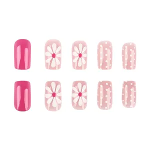 Short square glossy pink press-on nails with white daisy and polka dot pattern detail