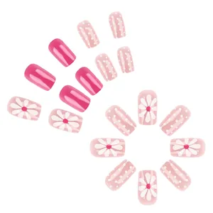 Short glossy daisy press-on nails with white polka dots and vibrant pink accents