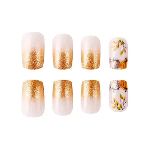 Short square press-on nails with autumn pumpkin and gold glitter maple leaf designs