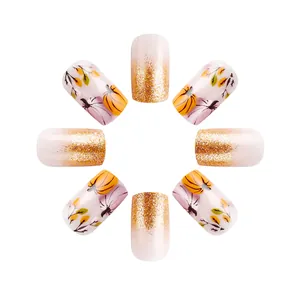 Detail of short pumpkin and glitter French nails with autumn leaf patterns