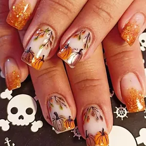 Detailed view of Halloween pumpkin and maple leaf patterns on short glossy press-on nails