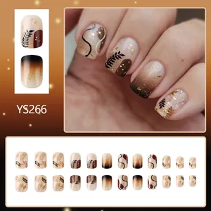 Short glossy brown press-on nails with maple leaf patterns and gold foil design