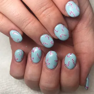 Detail showing glossy blue short square press-on nails with cute pink candy cane patterns