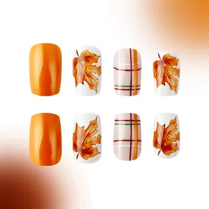 Short square press-on nails set featuring orange glossy finish with maple leaf designs