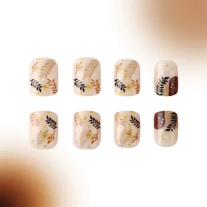 Short square press-on nails with autumn brown leaves, gold glitter and glossy finish