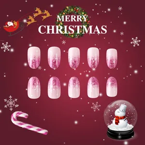 Short oval Christmas nails with pink gradient, glitter, and white snowflake patterns