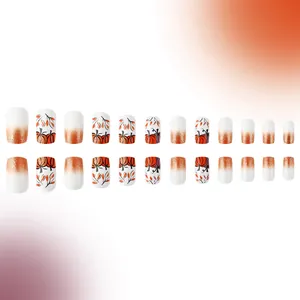 Autumn press-on nails featuring pumpkin leaf designs and orange glitter gradients