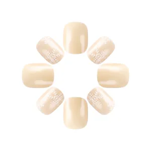 Close-up of pearl nude Christmas fake nails featuring delicate white snowflake patterns