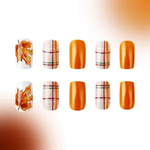 Short square orange glossy press-on nails with maple leaf art and plaid pattern