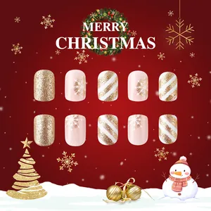 Detail of Christmas press-on nails with golden glitter, snowflakes, and striped patterns