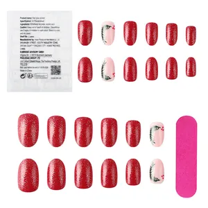 Detail of Christmas nails set with red glitter, leaf patterns, adhesive tabs and file