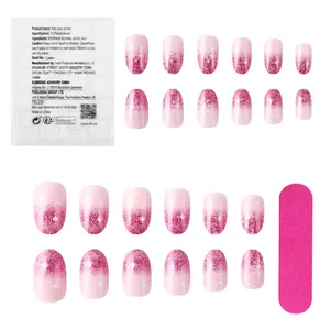 Detail of pink gradient glitter press-on nails with white snowflakes and star motifs