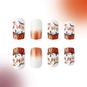Close-up of pumpkin design and orange glitter gradient on short glossy press-on nails