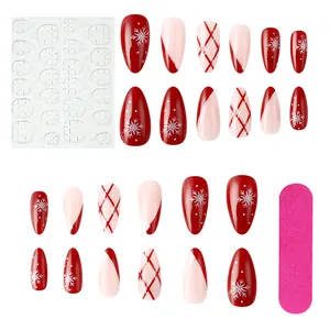 Flat lay of Christmas press-on nails set with snowflakes patterns and manicure tools