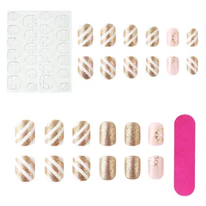 Detail of Christmas nail set with 24 gold glitter snowflake press-on nails and tools