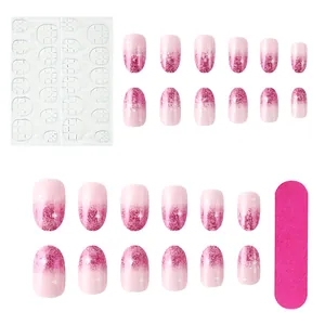 Short oval press-on nails set with pink glitter gradient, snowflakes and manicure tools