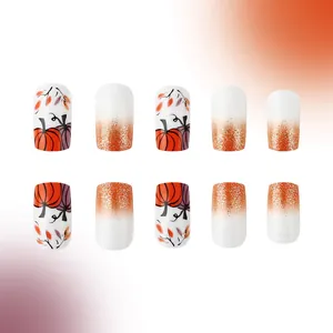 Macro detail of French pumpkin press-on nails with autumn glitter and leaf patterns