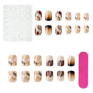 Short brown false nail set with leaf prints, glitter flakes and jelly glue stickers